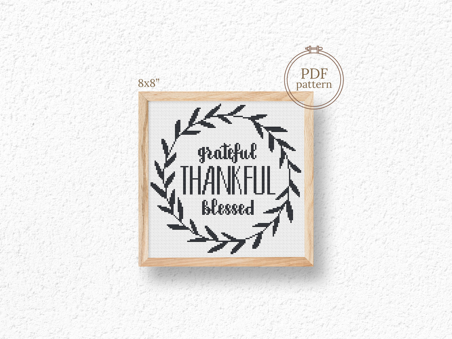 Framed cross-stitch pattern with 'Grateful Thankful Blessed' text and leaf design on a white background.