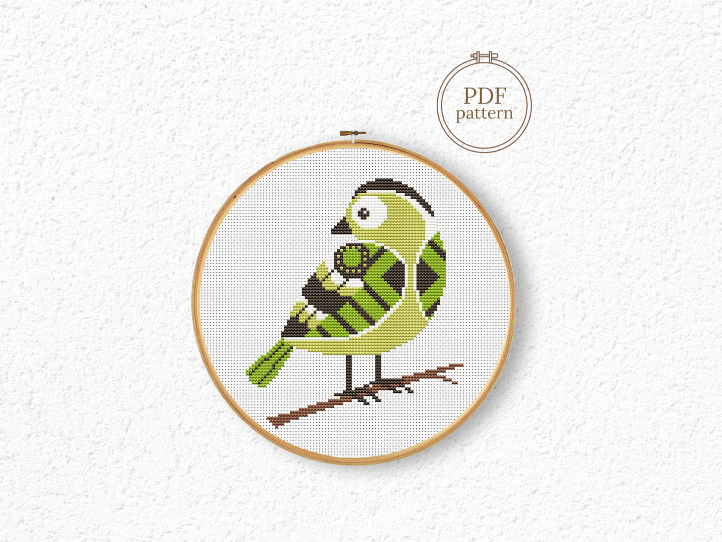 Green bird cross stitch pattern with detailed feathers and elegant nature design