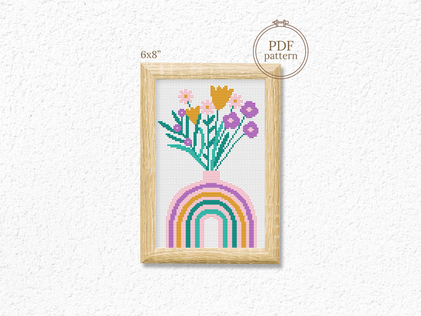 Cross-stitch pattern with flowers and rainbow on a white background