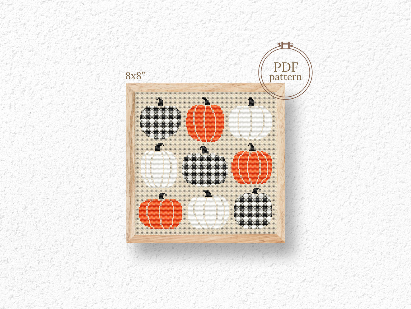 Cross-stitch pattern with pumpkins on a textured white background