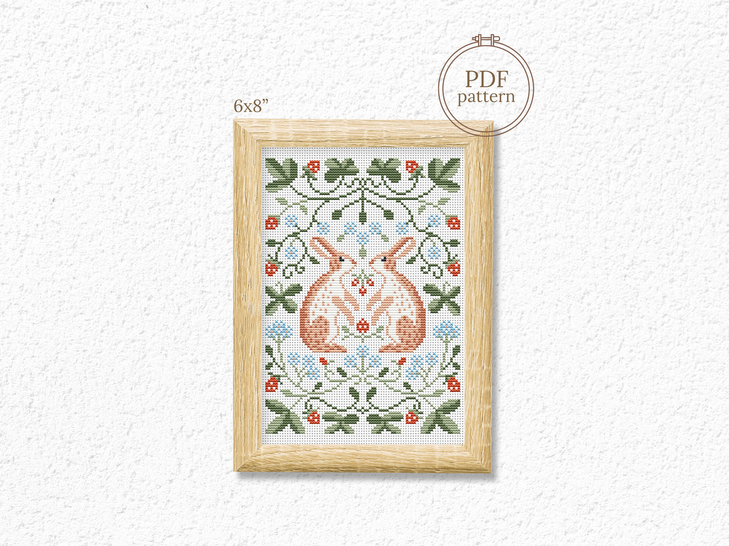 Folk cross stitch pattern with rabbits, leaves, and strawberries in woodland style