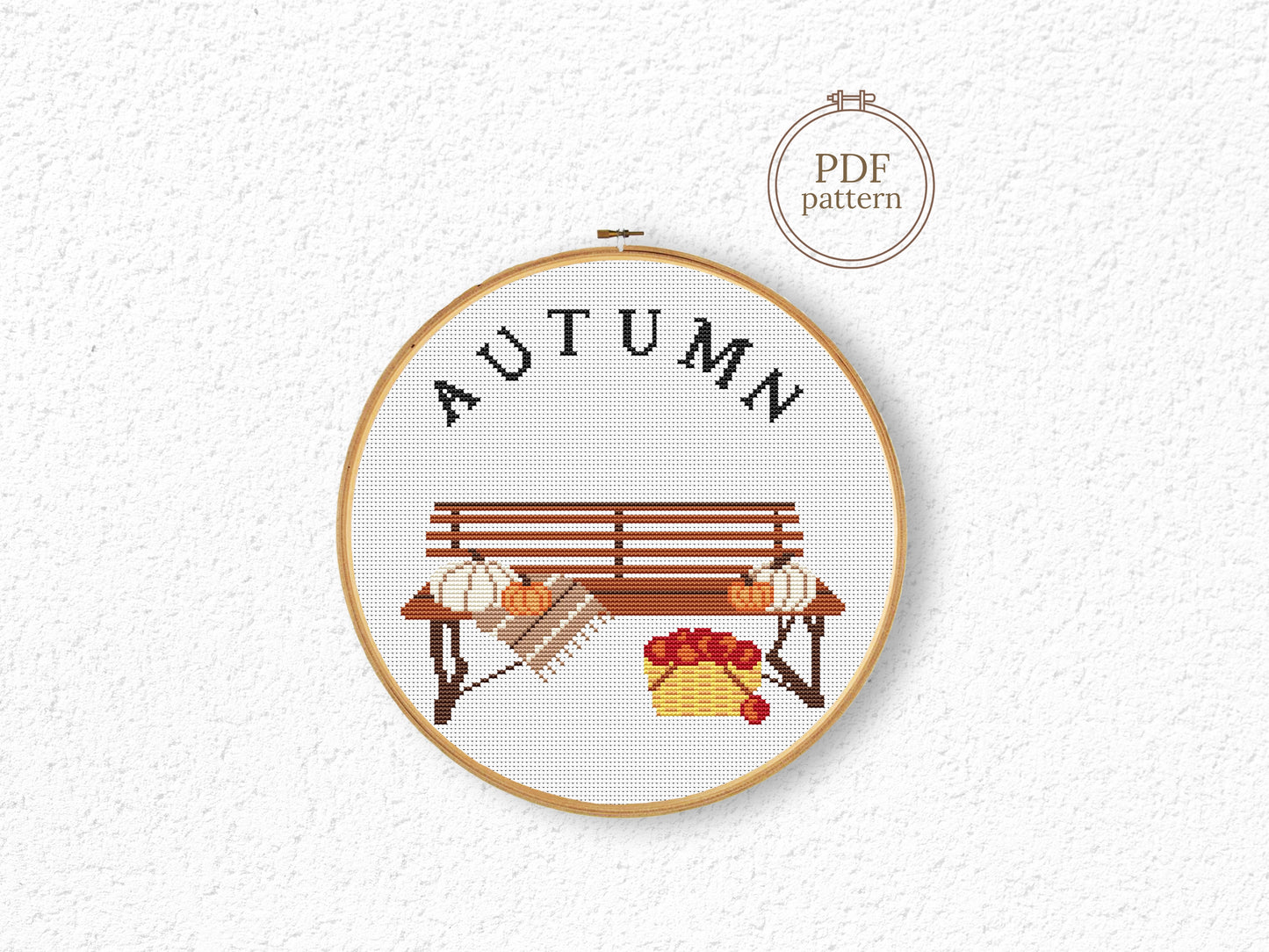 Cross stitch pattern with pumpkins on a bench and "Autumn" text, rustic cozy fall PDF design