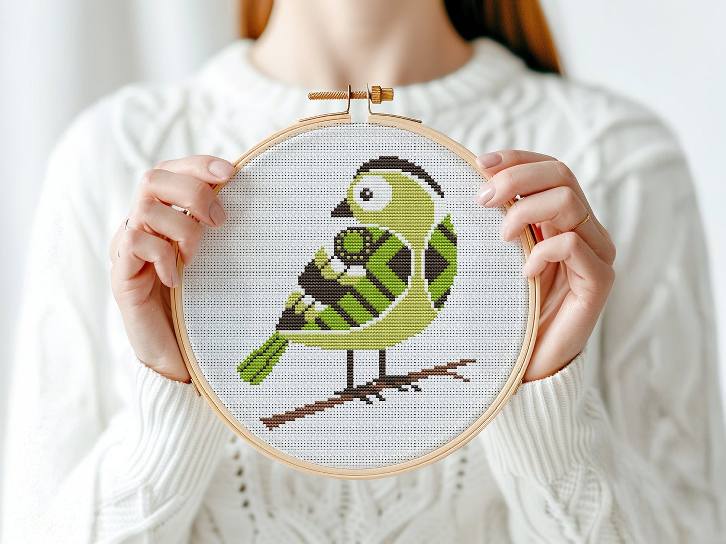 Green bird cross stitch pattern with detailed feathers and elegant nature design