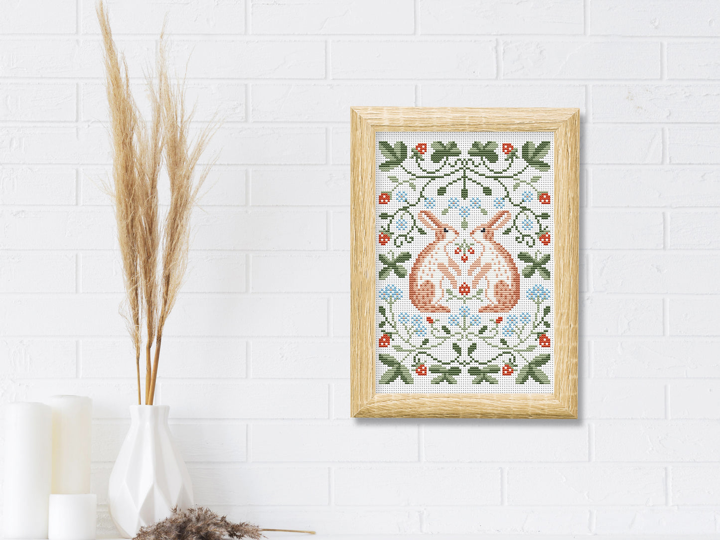 Folk cross stitch pattern with rabbits, leaves, and strawberries in woodland style