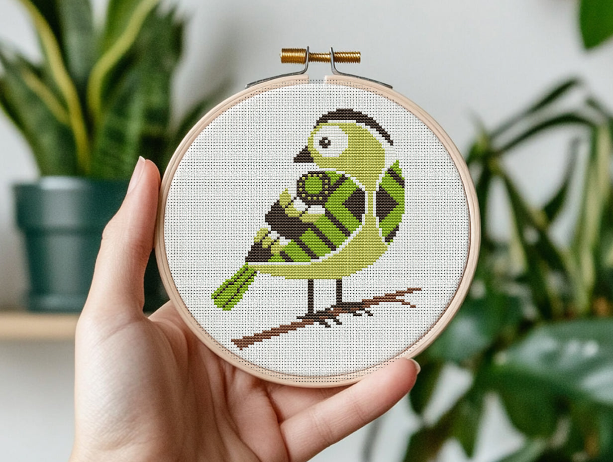 Green bird cross stitch pattern with detailed feathers and elegant nature design