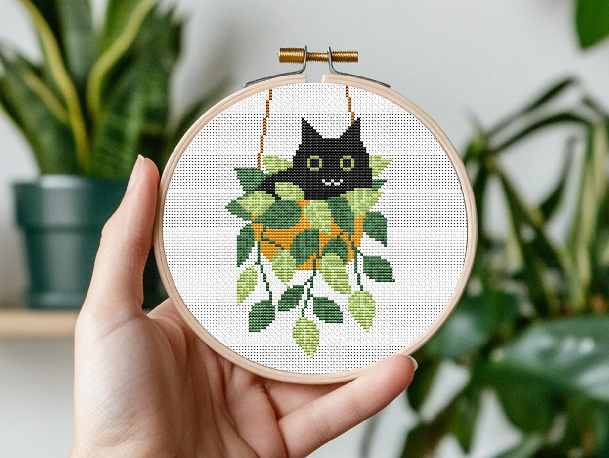 Cute relaxed cat cross stitch pattern sitting in plant pot, peaceful and cozy design
