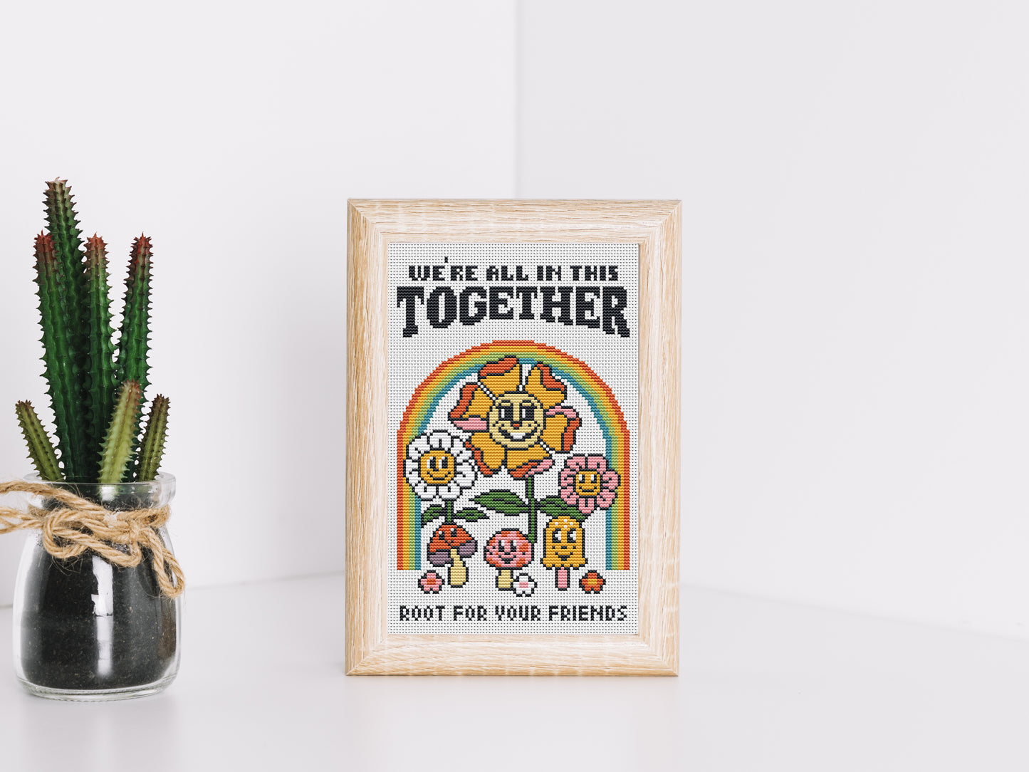Cartoon-style cross stitch pattern with phrase "We All In This Together", modern colorful trendy design
