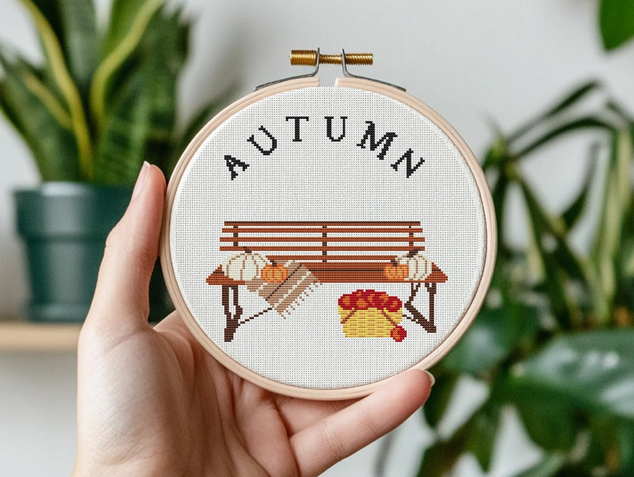 Cross stitch pattern with pumpkins on a bench and "Autumn" text, rustic cozy fall PDF design