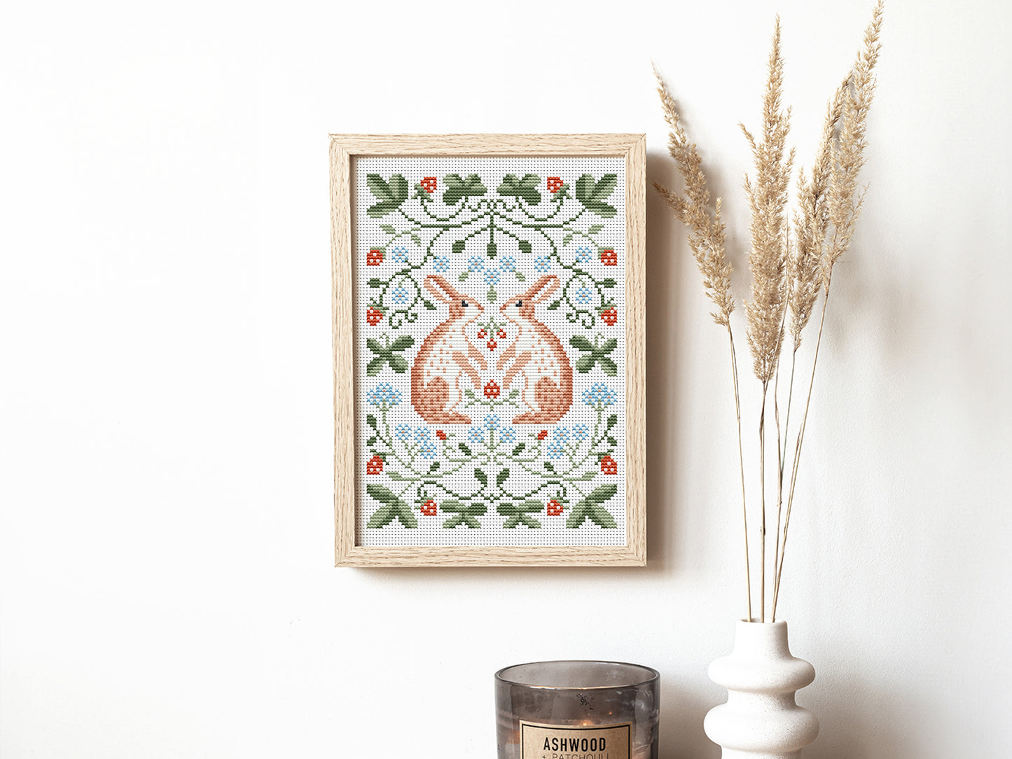 Folk cross stitch pattern with rabbits, leaves, and strawberries in woodland style