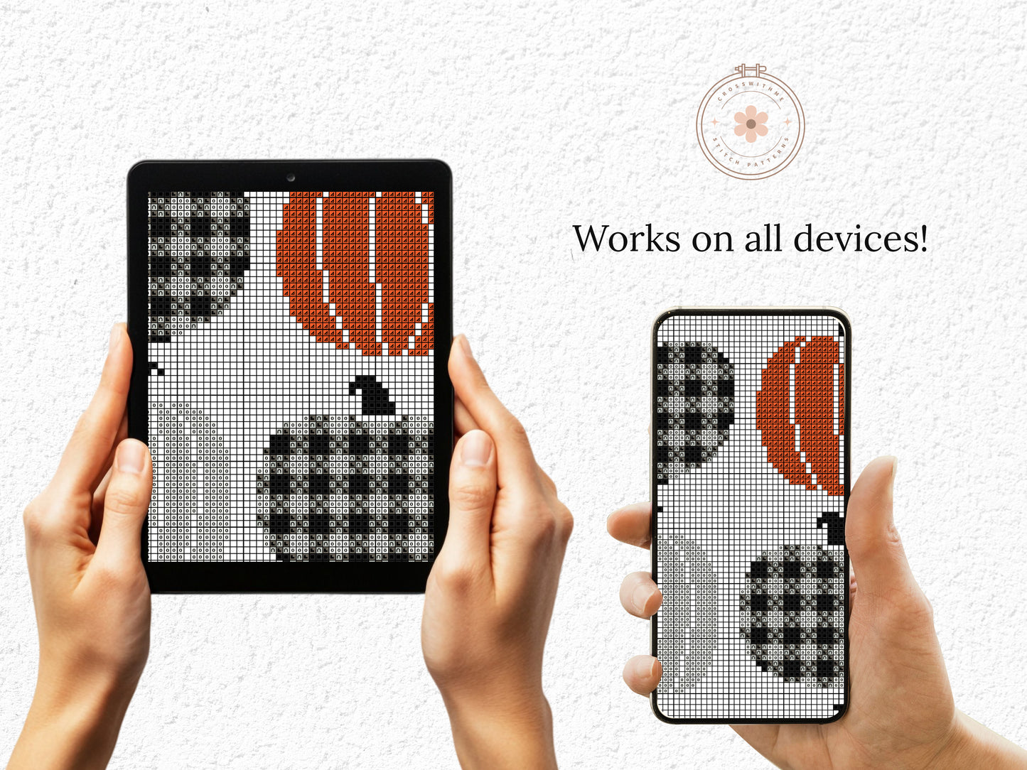 Hands holding a tablet and phone displaying cross-stitch patterns of pumpkins and leaves.