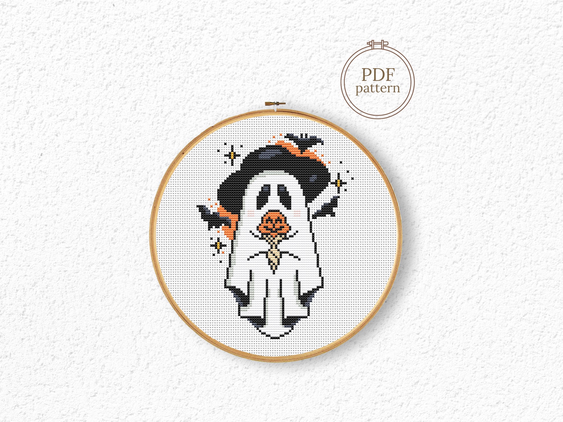 Halloween cross stitch pattern with a ghost holding a pumpkin