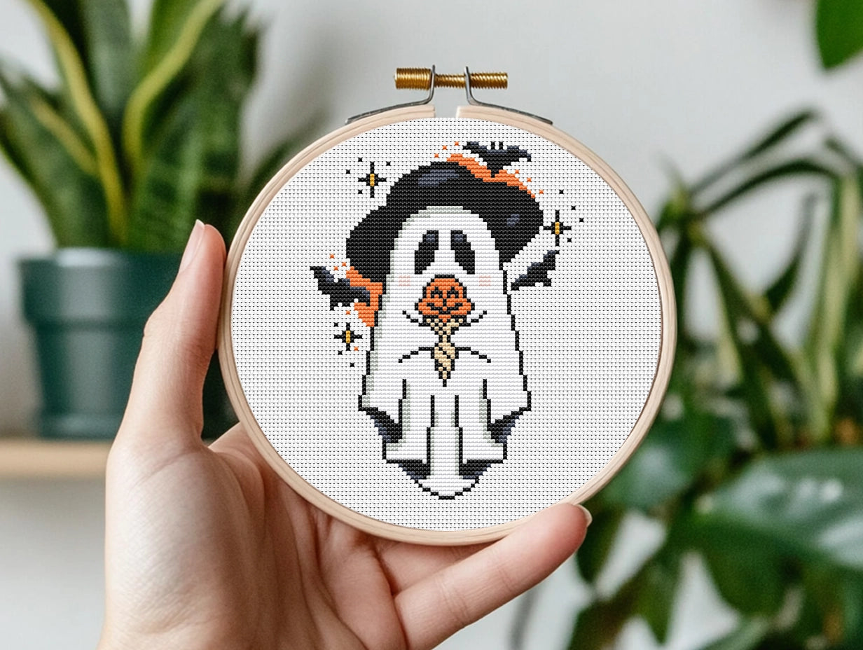 Halloween cross stitch pattern with a ghost holding a pumpkin
