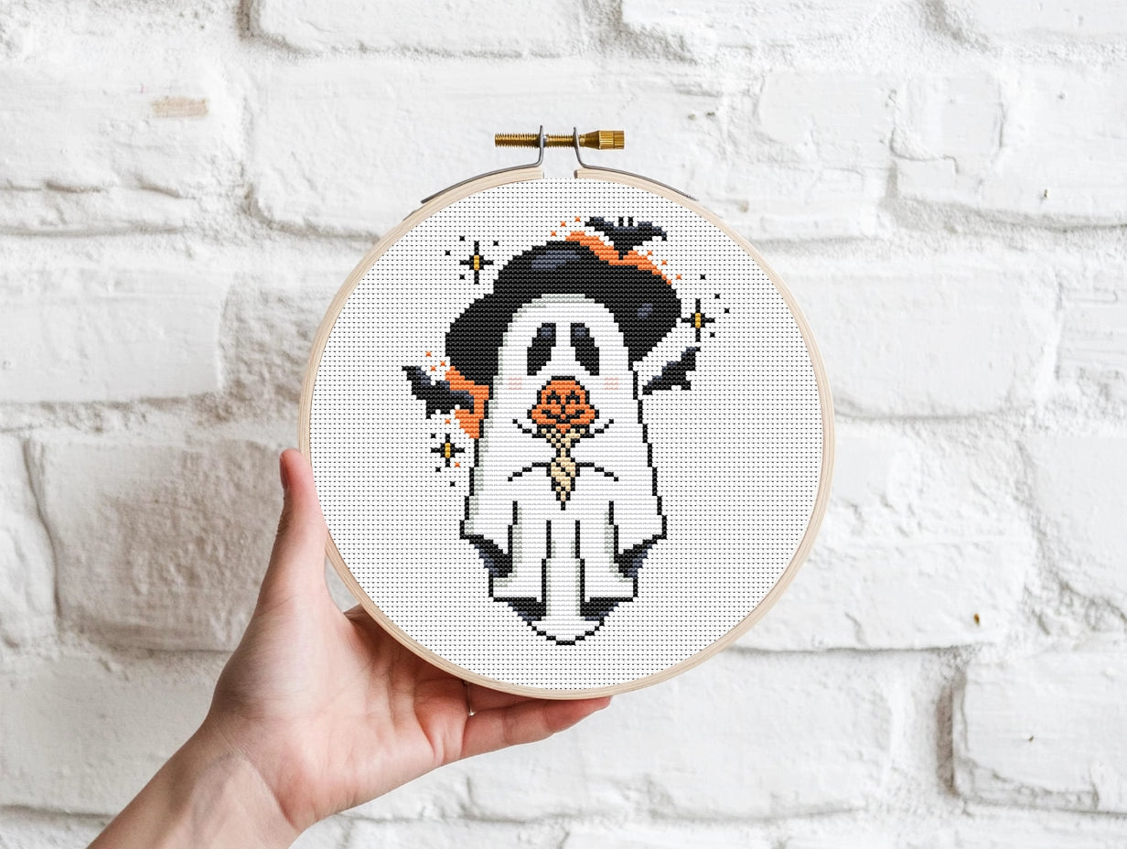 Halloween cross stitch pattern with a ghost holding a pumpkin