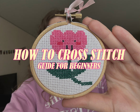 Beginner cross stitch flower with hands, hoop, and fabric