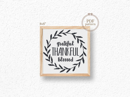 Framed cross-stitch pattern with 'Grateful Thankful Blessed' text and leaf design on a white background.