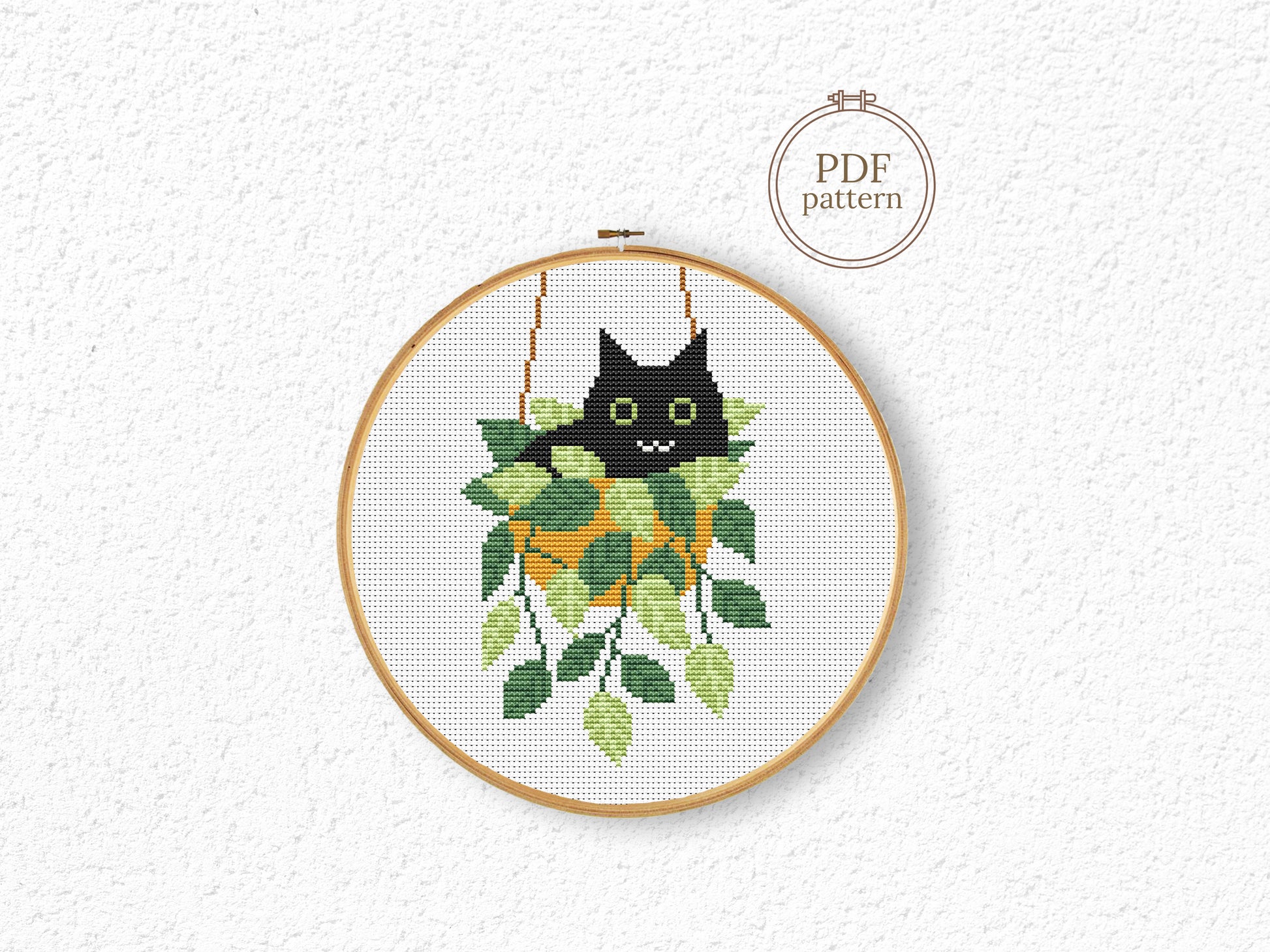 Cute relaxed cat cross stitch pattern sitting in plant pot, peaceful and cozy design