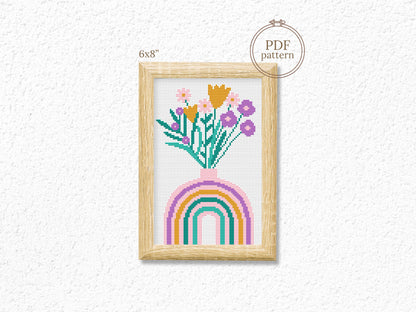 Cross-stitch pattern with flowers and rainbow on a white background