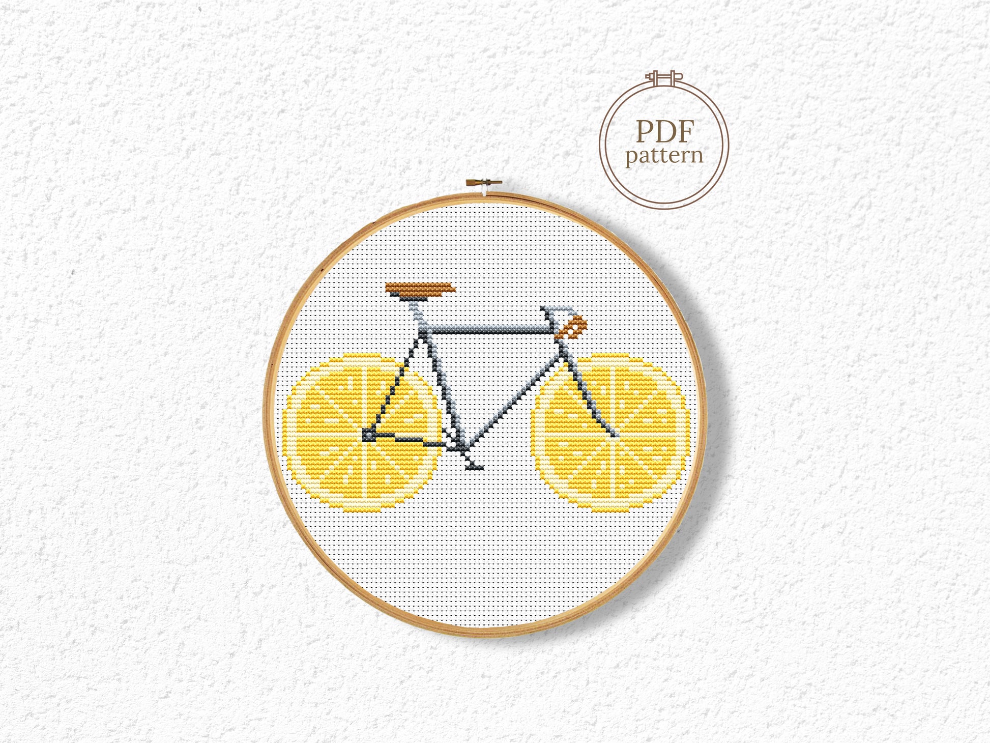 Embroidery hoop with bicycle design on a white background