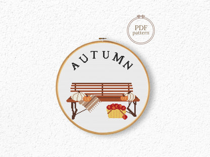 Cross stitch pattern with pumpkins on a bench and "Autumn" text, rustic cozy fall PDF design