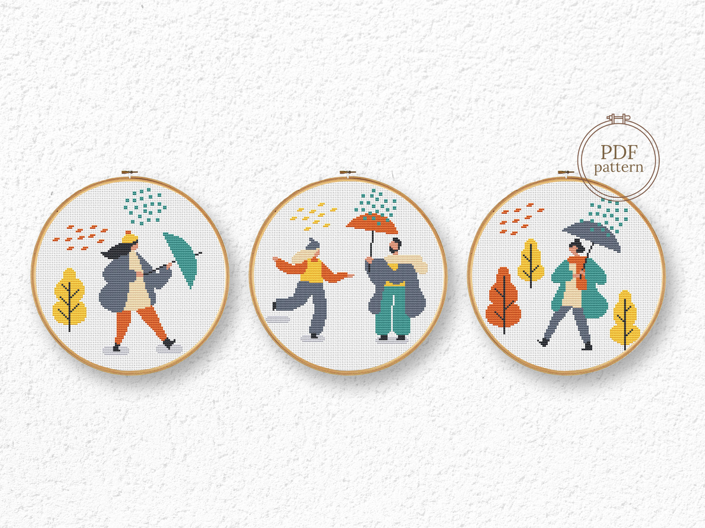 Set of three autumn cross stitch patterns with people, umbrellas, rain, and puddle