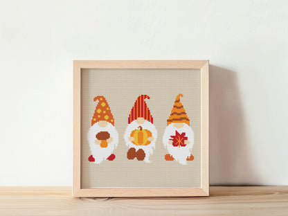 Framed cross-stitched gnomes on a white background