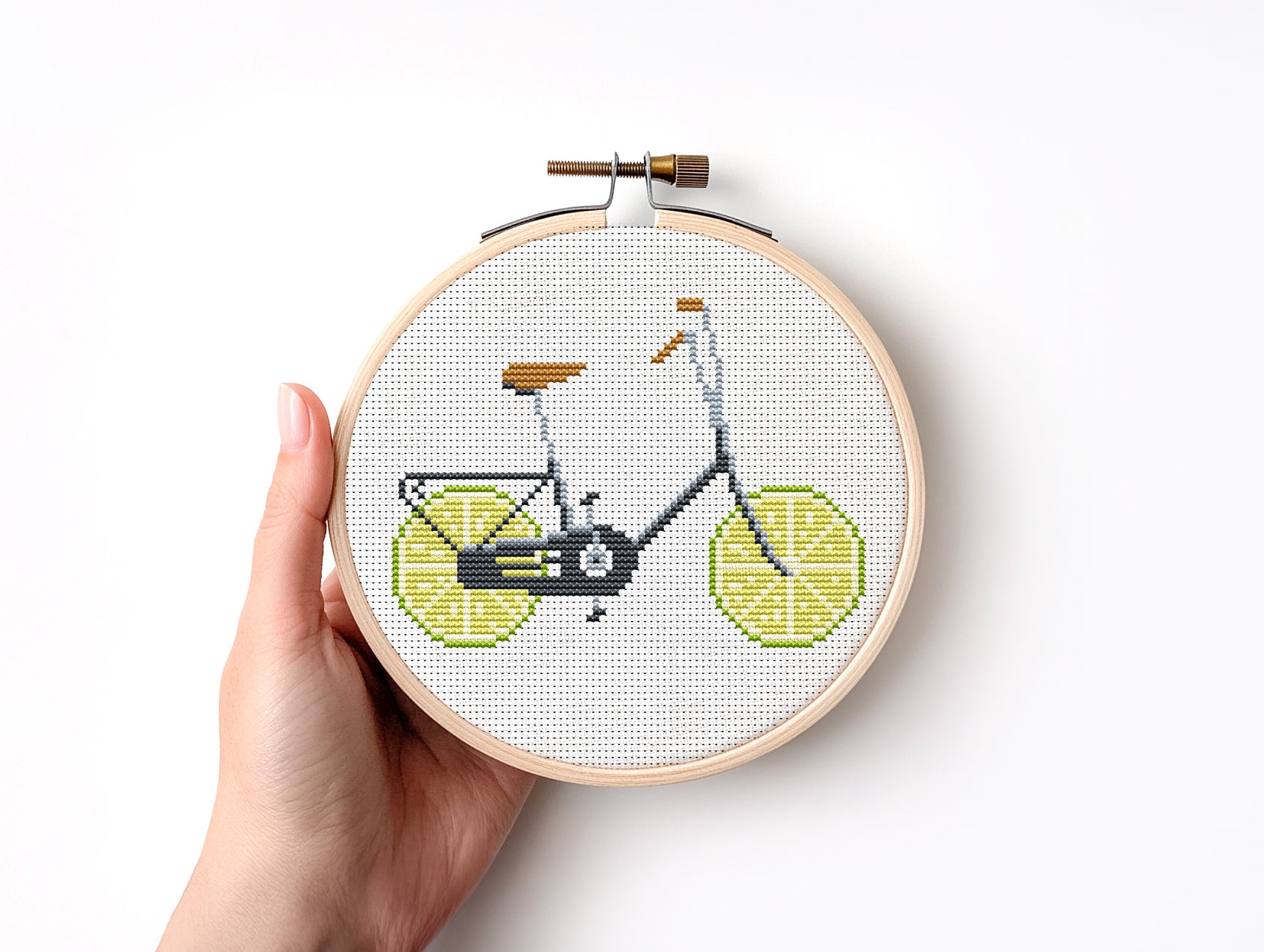 Embroidery hoop with a bicycle design on a white background