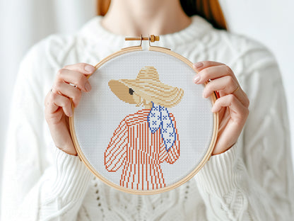 Cross stitch pattern of a woman in a hat looking at the ocean, minimalist summer beach PDF design