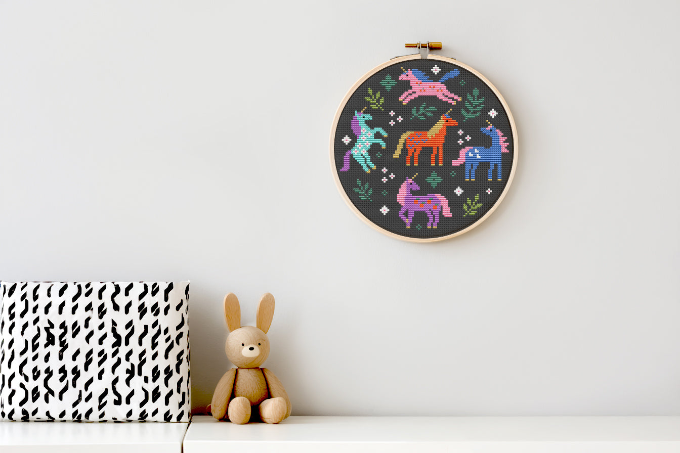 Colorful unicorns surrounded by leaves cross stitch pattern, whimsical fantasy PDF embroidery design.