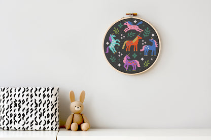 Colorful unicorns surrounded by leaves cross stitch pattern, whimsical fantasy PDF embroidery design.