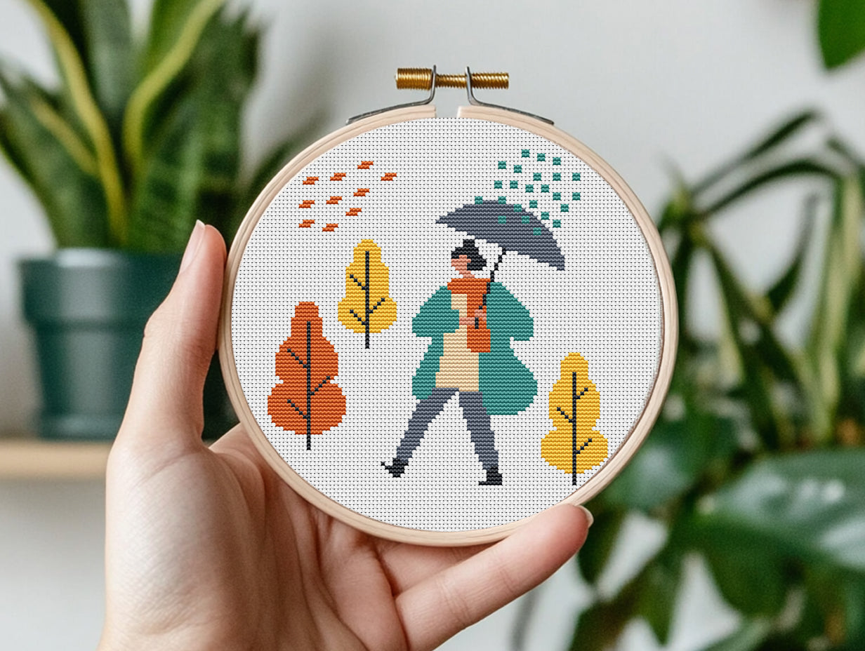 Set of three autumn cross stitch patterns with people, umbrellas, rain, and puddle