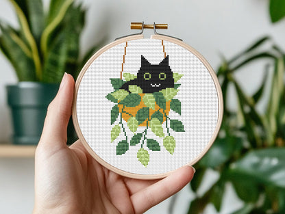 Cute relaxed cat cross stitch pattern sitting in plant pot, peaceful and cozy design