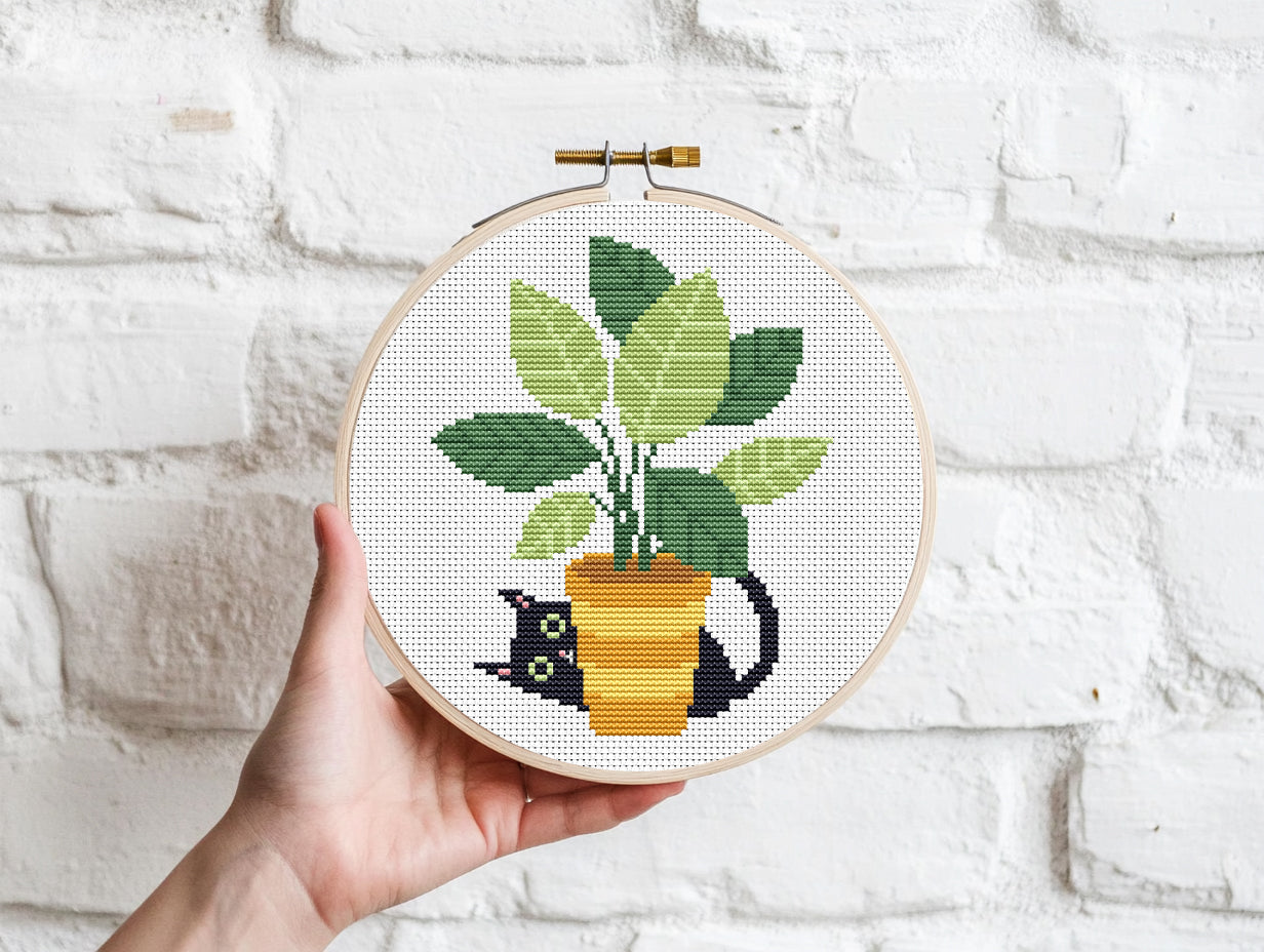 Black cat cross stitch pattern sitting in a flower pot, cozy and expressive design