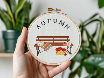 Cross stitch pattern with pumpkins on a bench and "Autumn" text, rustic cozy fall PDF design