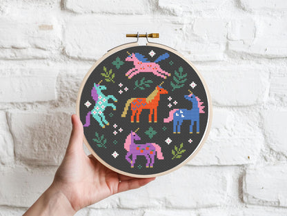 Colorful unicorns surrounded by leaves cross stitch pattern, whimsical fantasy PDF embroidery design.