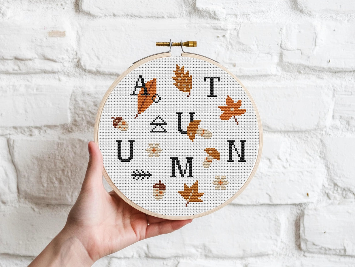 Cross stitch pattern of the word "Autumn" with fall leaves, cozy seasonal PDF design