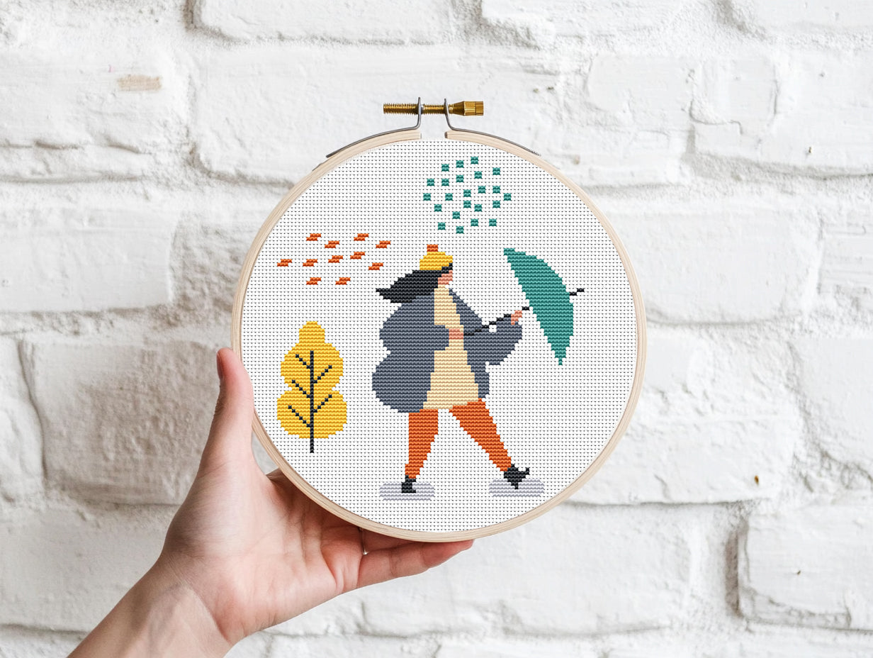 Set of three autumn cross stitch patterns with people, umbrellas, rain, and puddle